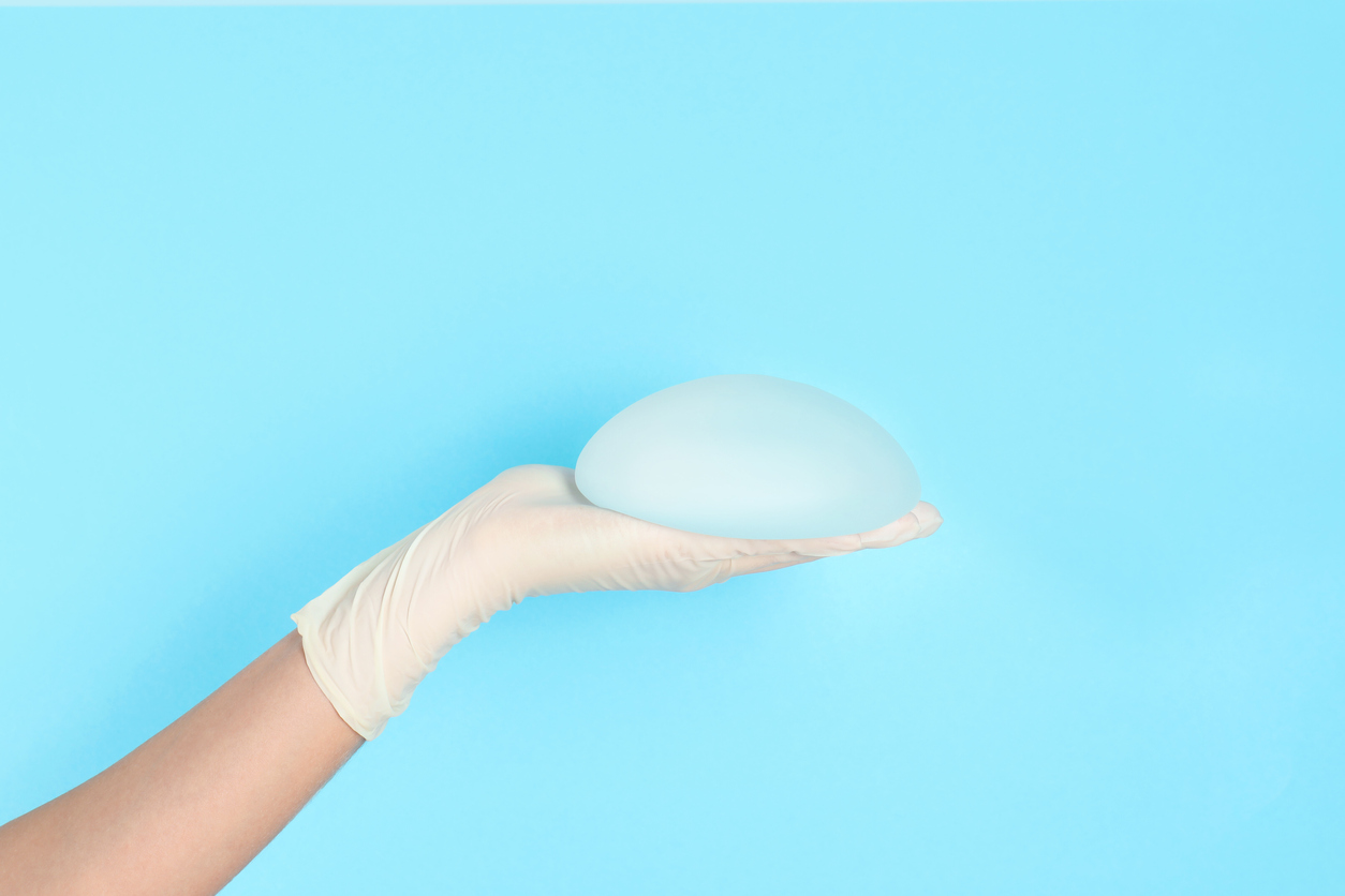 Hand holding breast implants