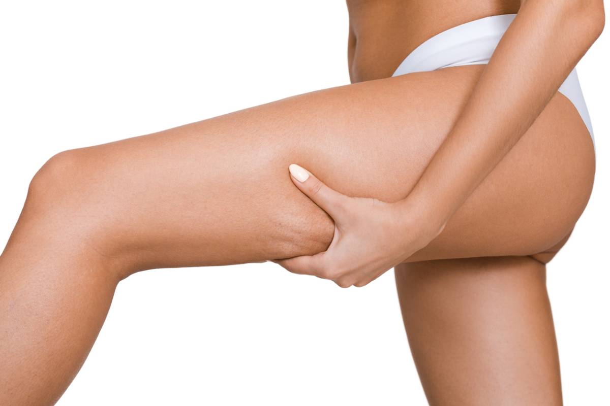 A woman confidently poses with her legs raised and hands on her hips, exuding strength and self-assurance.