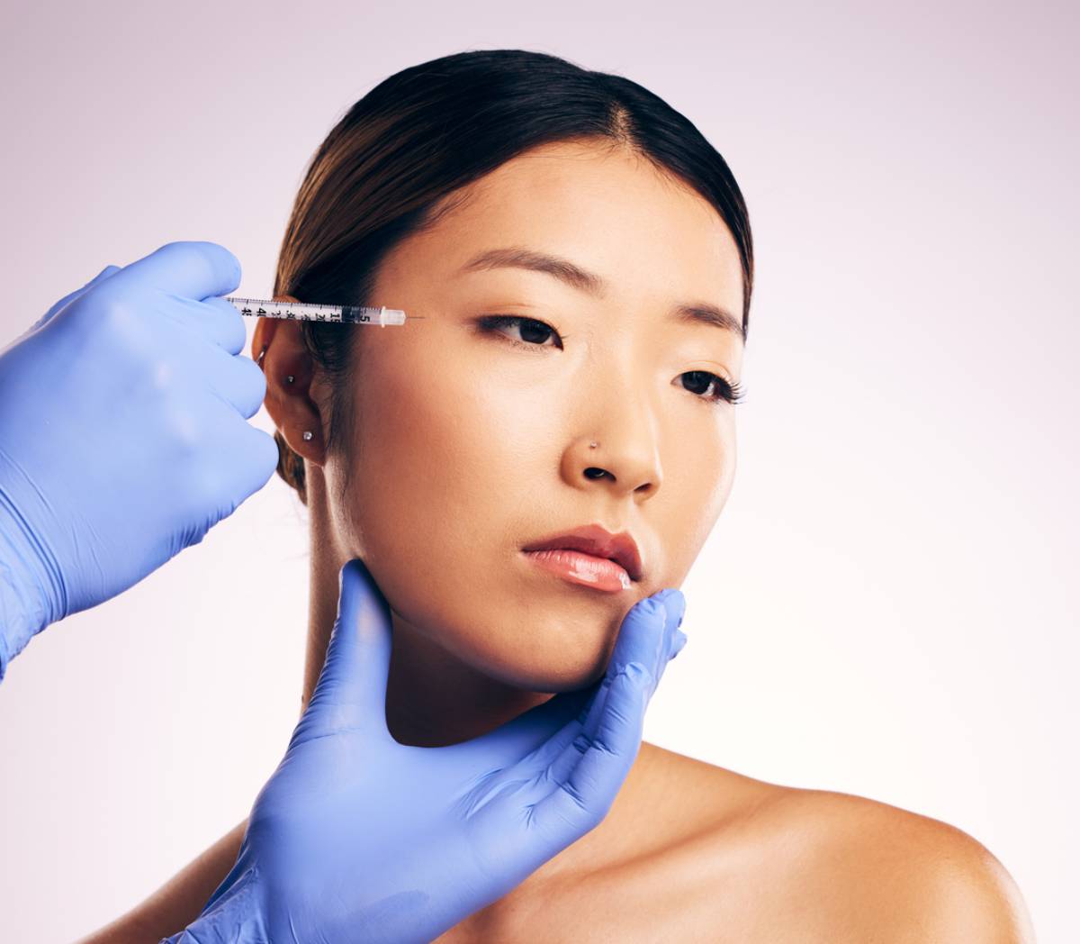 Woman undergoing cosmetic procedure with injections.