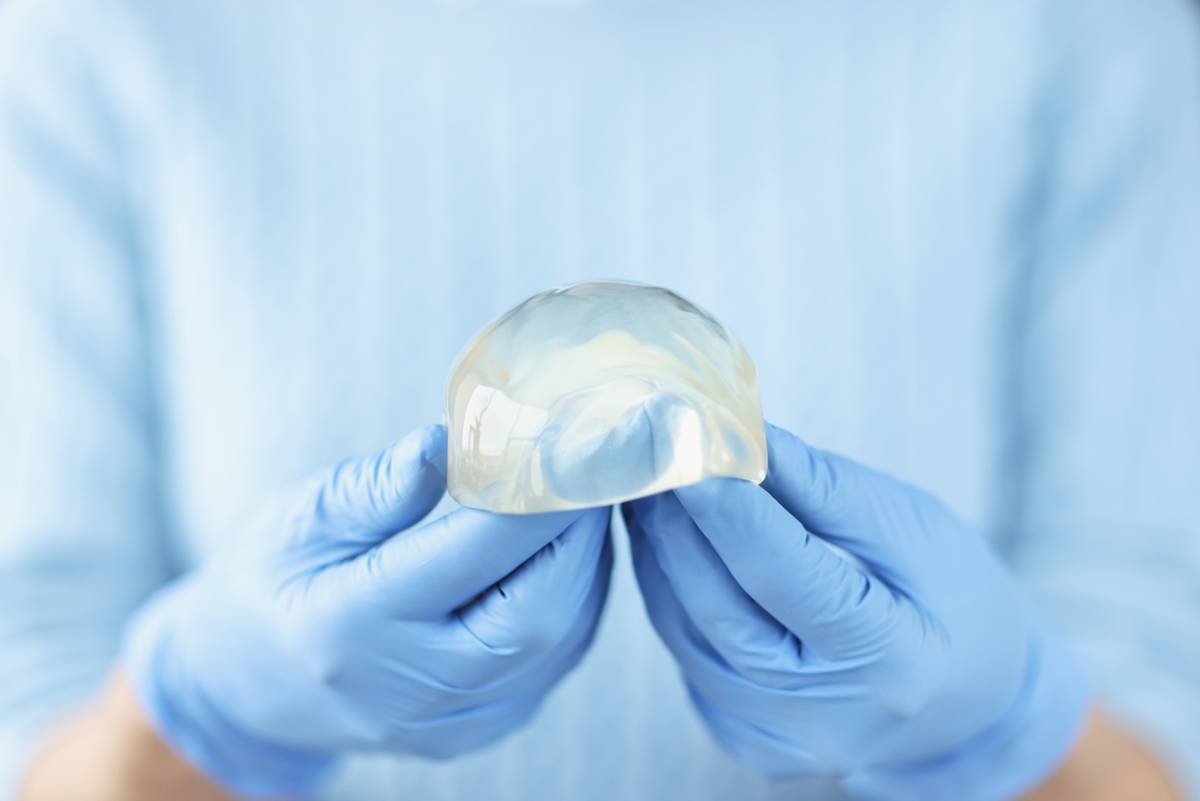 A person wearing blue gloves is carefully holding a tooth, showcasing dental care and hygiene practices.