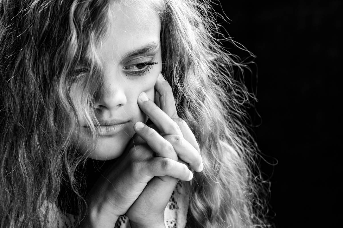 A black and white photograph featuring a girl with long hair, capturing her serene expression and timeless beauty.